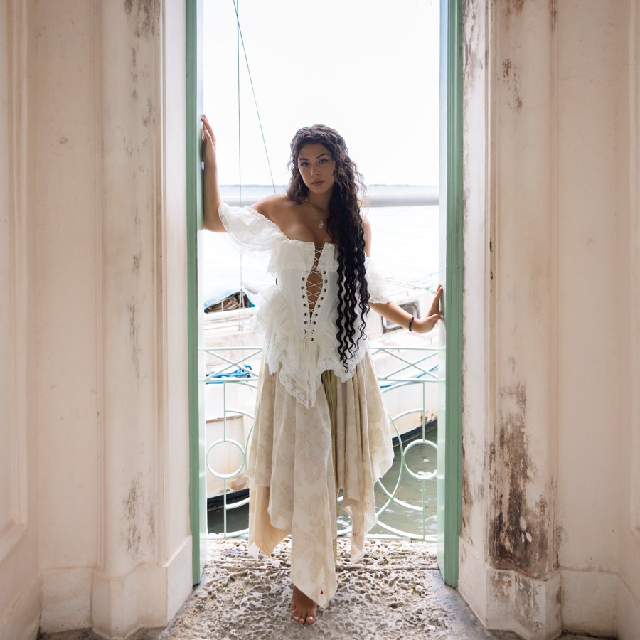 Siren Songs EP cover: Bella Valdes in white lace, framed in a weathered Vizcaya doorway above the water.